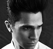 Black-and-white portrait of a male model with a tall pompadour and tapered sides